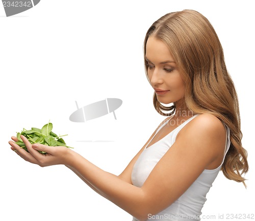 Image of woman with spinach leaves on palms