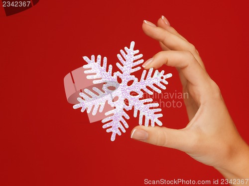 Image of woman's hands holding a snowflake