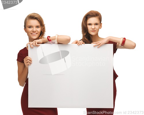 Image of two teenage girls in red dresses with blank board