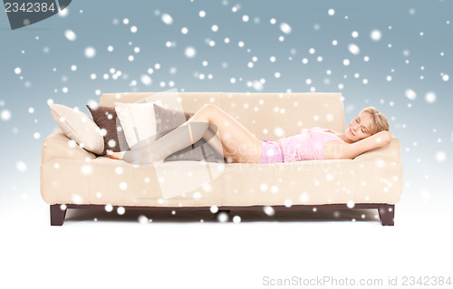 Image of sleeping woman on sofa with snow