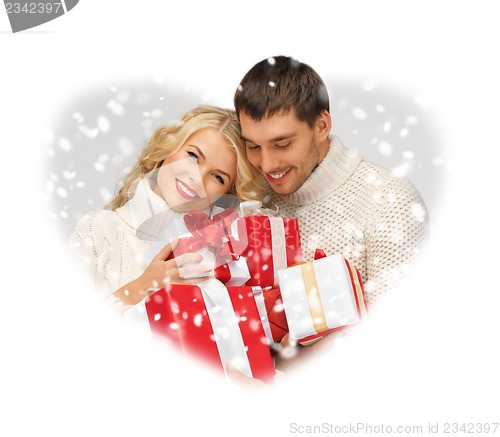 Image of romantic couple in a sweaters with gift boxes