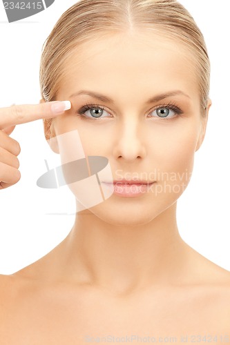 Image of beautiful woman pointing to eye