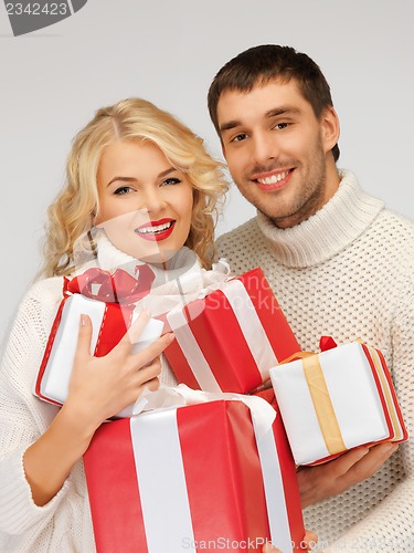 Image of family couple in a sweaters with gift boxes