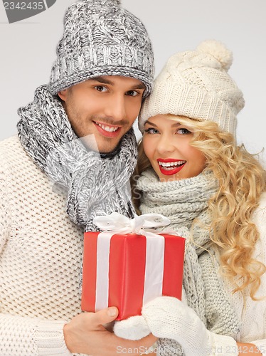 Image of romantic couple in a sweaters with gift box