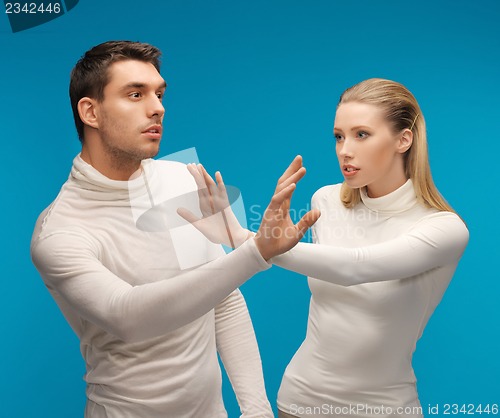 Image of man and woman working with something imaginary