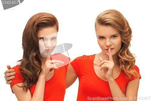 Image of two teenage girls showing hush gesture
