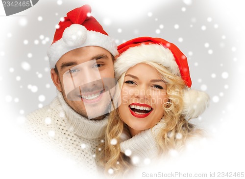 Image of family couple in sweaters and santa's hats