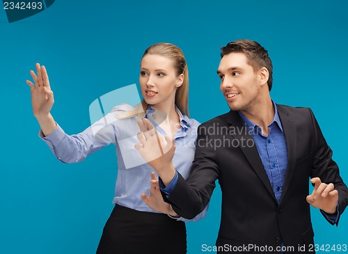 Image of man and woman working with something imaginary