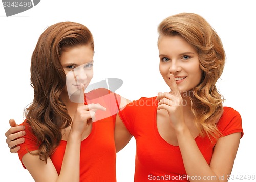 Image of two teenage girls showing hush gesture