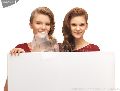 Image of two teenage girls in red dresses with blank board
