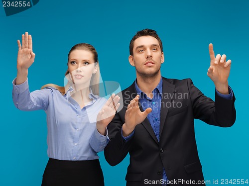 Image of man and woman working with something imaginary