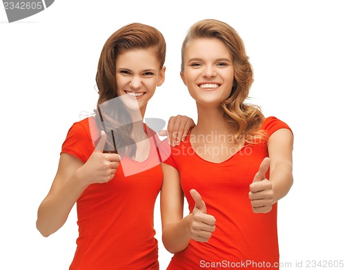 Image of wo teenage girls in red t-shirts showing thumbs up