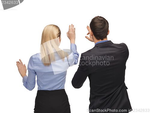 Image of man and woman working with something imaginary