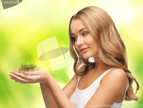 Image of woman with green grass on palms