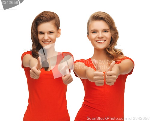 Image of wo teenage girls in red t-shirts showing thumbs up