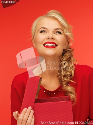 Image of lovely woman in red dress with opened gift box