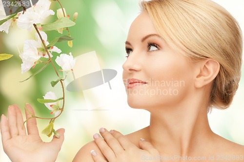 Image of beautiful woman with flowers on twig