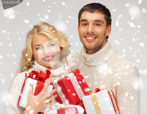 Image of family couple in a sweaters with gift boxes