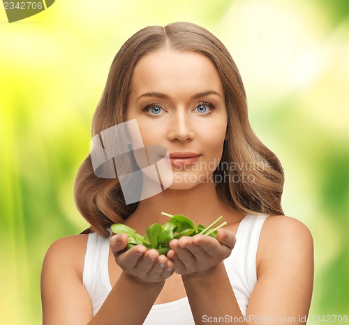 Image of woman with spinach leaves on palms