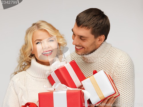 Image of family couple in a sweaters with gift boxes
