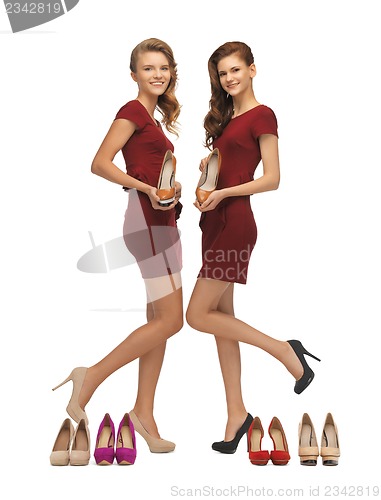 Image of two lovely teenage girls in red dresses with shoes