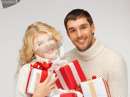 Image of family couple in a sweaters with gift boxes