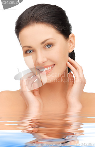 Image of face and hands of beautiful woman in water