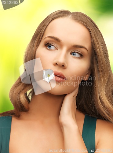 Image of woman with camomile in mouth