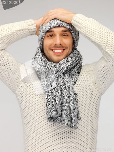 Image of handsome man in warm sweater, hat and scarf