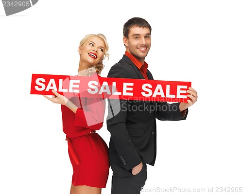 Image of man and woman with sale sign