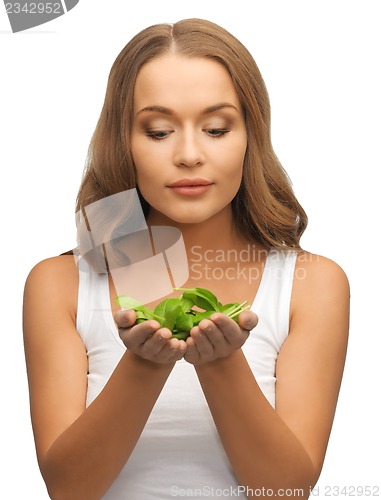 Image of woman with spinach leaves on palms