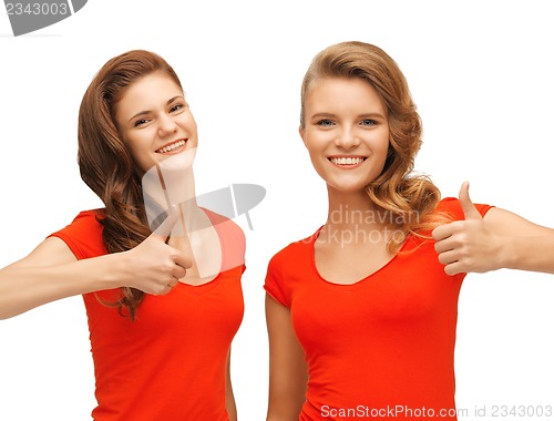 Image of wo teenage girls in red t-shirts showing thumbs up