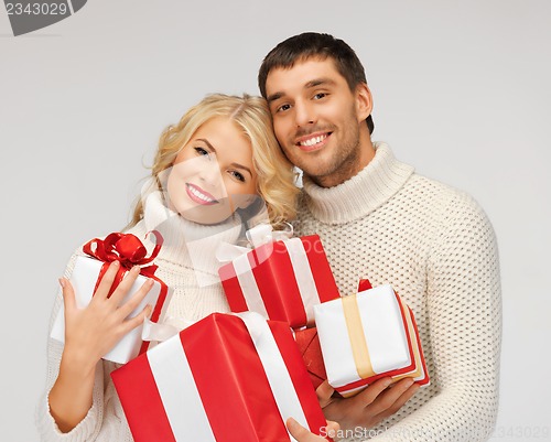 Image of romantic couple in a sweaters with gift boxes