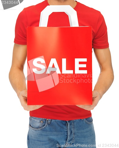 Image of man's hands holding shopping bag