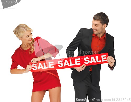 Image of man and woman with sale sign