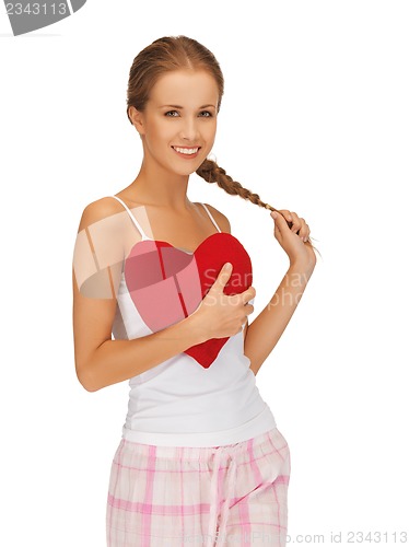 Image of happy and smiling woman with heart-shaped pillow