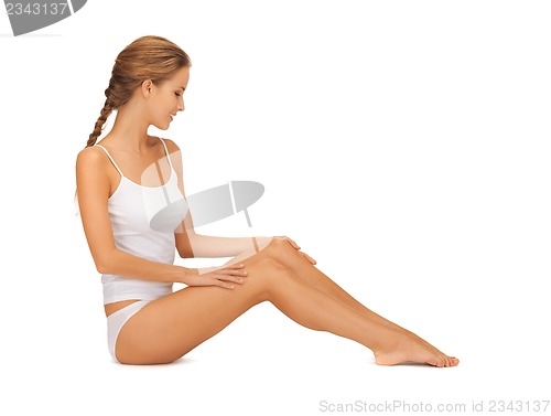 Image of woman in cotton undrewear touching her legs