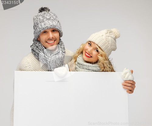 Image of couple in a winter clothes holding blank board