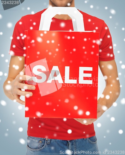 Image of man's hands holding shopping bag