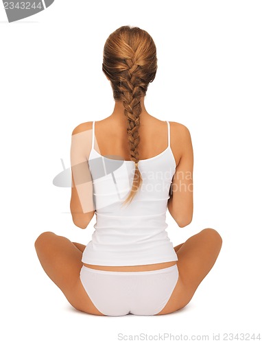 Image of woman in undrewear practicing yoga lotus pose