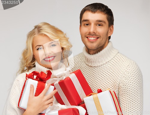 Image of family couple in a sweaters with gift boxes