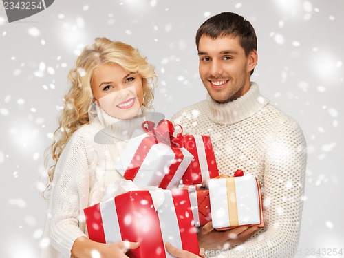 Image of family couple in a sweaters with gift boxes