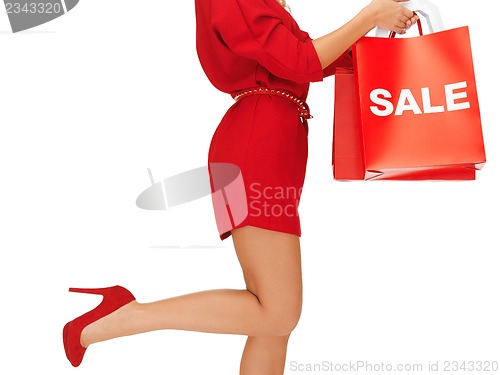 Image of woman on high heels holding shopping bags