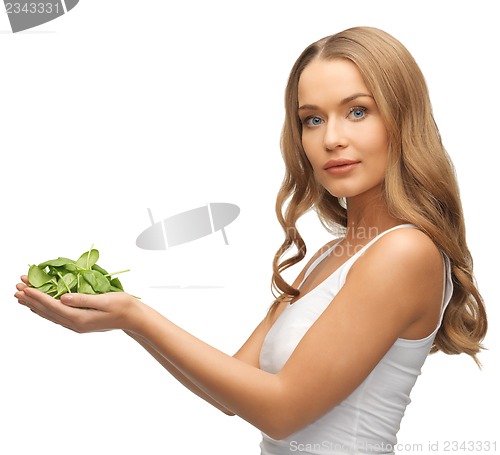 Image of woman with spinach leaves on palms