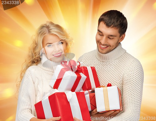 Image of family couple in a sweaters with gift boxes