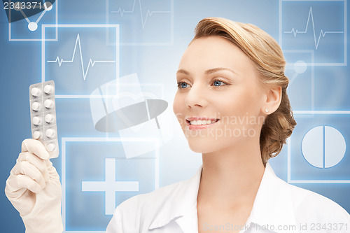 Image of attractive female doctor with pills