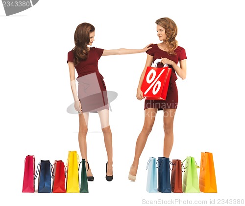 Image of teenage girls in red dresses with shopping bags