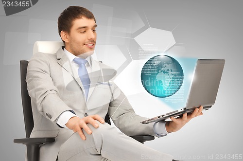 Image of businessman with laptop and virtual screens