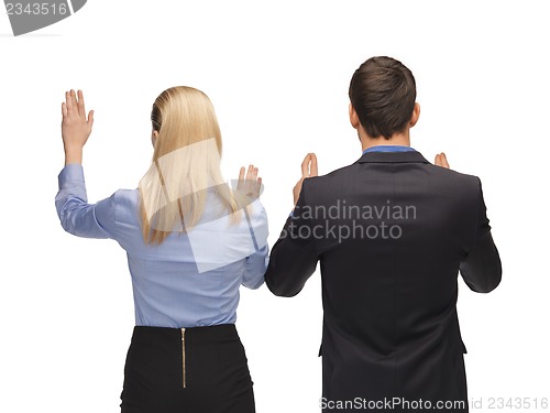 Image of man and woman working with something imaginary