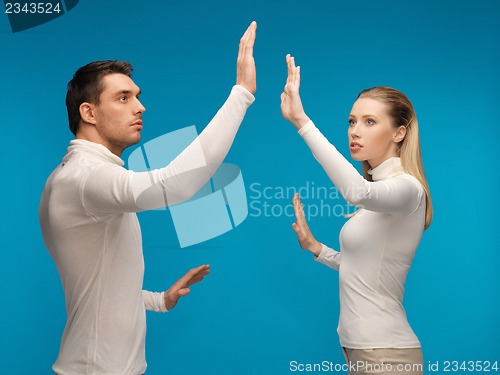 Image of man and woman working with something imaginary